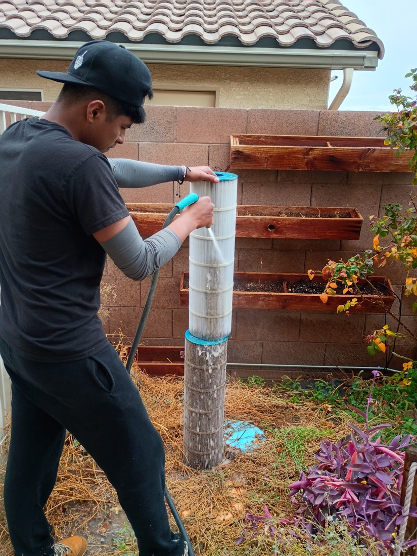 Excellent Pool Care technician rinsing a pool filter cartridge