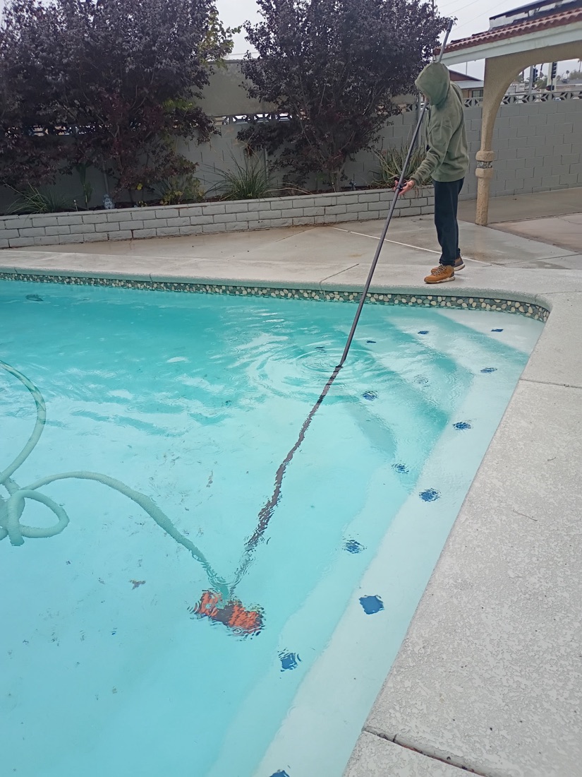 Excellent Pool Care technician vacuuming a pool